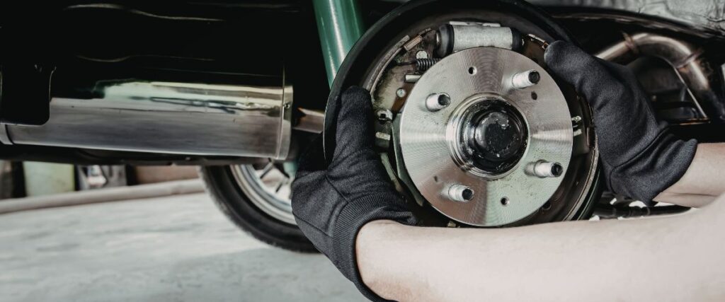 mechanic inspecting brake caliper and pads